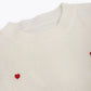 détail broderie cœur pull femme